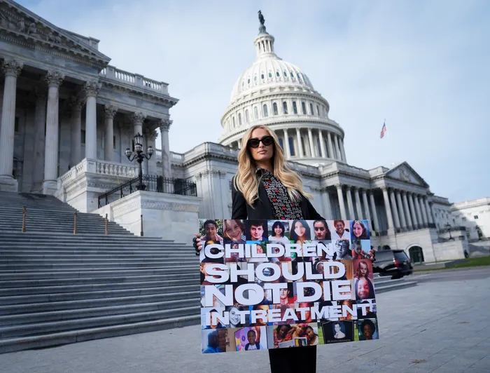 Paris Hilton holds a protest sign on the steps of the US Capitol to celebrate the passage of SICAA